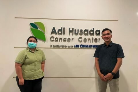 Dokumentasi Mahasiswa Bersama Pembimbing Lapangan di Depan Logo Adi Husada Cancer Center sebagai Lokasi Pelaksanaan Kegiatan Magang
