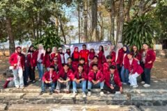 Foto bersama Mahasiswa Kelompok KKN 160 UMM berjaket almamater merah maroon di Tunas Kelapa Karangkates Desa Sumberpetung.