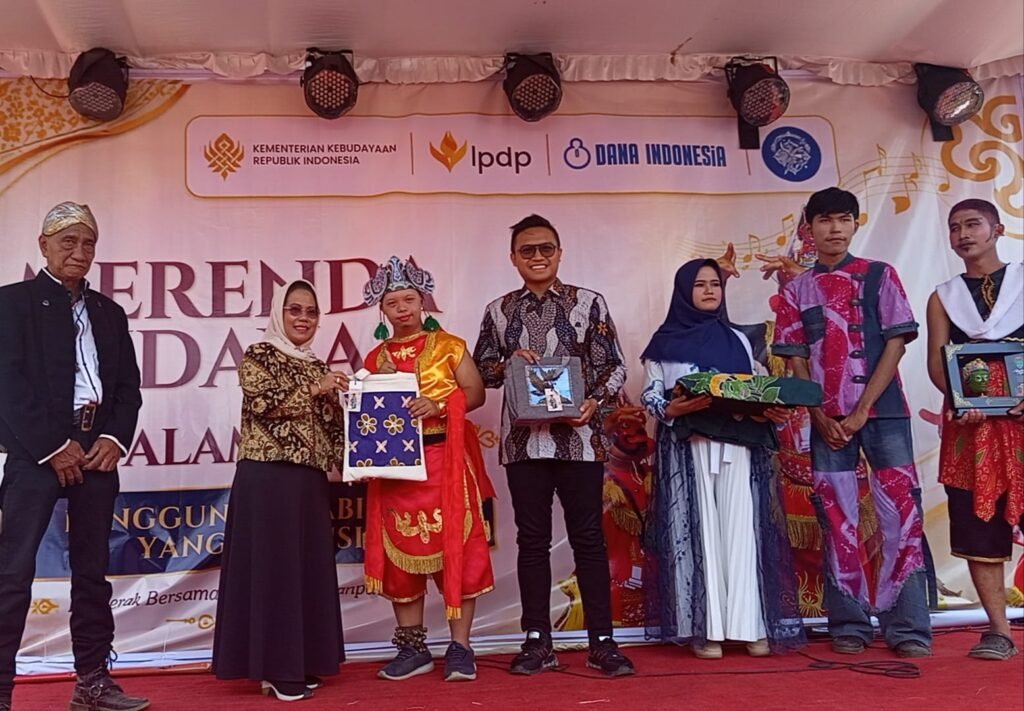 Potret kebersamaan saat penyerahan cenderamata dan apresiasi karya di atas panggung. Tampak perwakilan siswa SLB yang mengenakan busana daerah serta memegang produk hasil kerajinan tangan kebanggaan mereka dalam acara pameran yang didukung oleh Kementerian Kebudayaan dan LPDP.