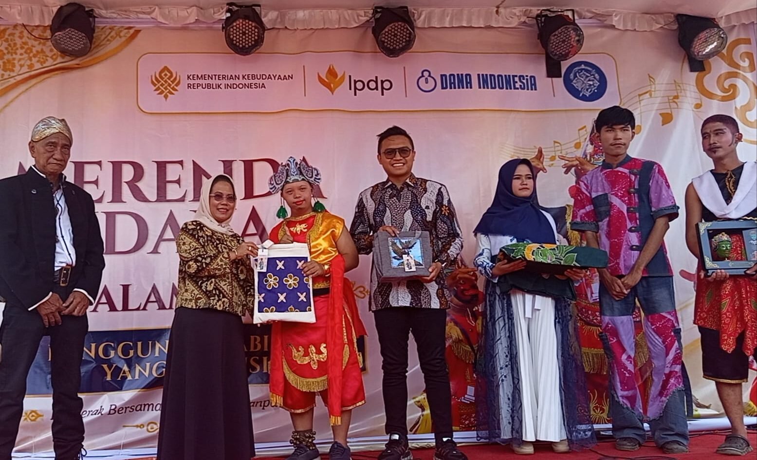 Potret kebersamaan saat penyerahan cenderamata dan apresiasi karya di atas panggung. Tampak perwakilan siswa SLB yang mengenakan busana daerah serta memegang produk hasil kerajinan tangan kebanggaan mereka dalam acara pameran yang didukung oleh Kementerian Kebudayaan dan LPDP.