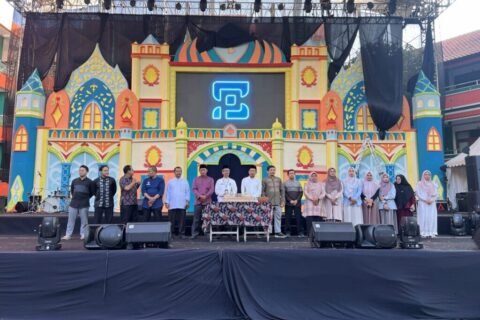 Jajaran pimpinan, guru, dan panitia MAN 2 Kota Malang mengabadikan momen kebersamaan usai prosesi pemotongan tumpeng di atas panggung utama yang berlatar dekorasi megah.