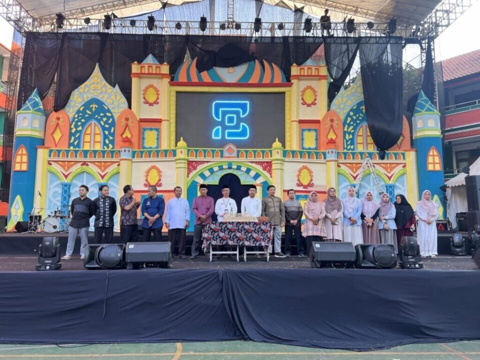 Jajaran pimpinan, guru, dan panitia MAN 2 Kota Malang mengabadikan momen kebersamaan usai prosesi pemotongan tumpeng di atas panggung utama yang berlatar dekorasi megah.