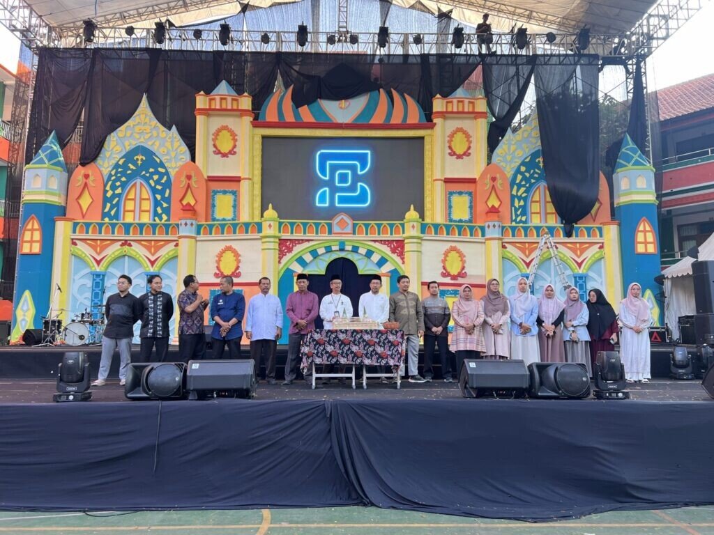 Jajaran pimpinan, guru, dan panitia MAN 2 Kota Malang mengabadikan momen kebersamaan usai prosesi pemotongan tumpeng di atas panggung utama yang berlatar dekorasi megah.