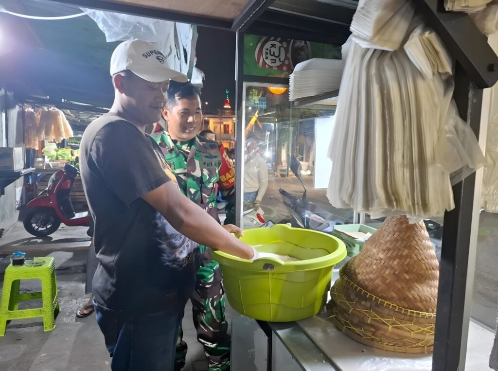 Babinsa Tunggulwulung, Serda Mahmudin, tampak tersenyum hangat saat berdialog dan memberikan motivasi kepada salah satu warga pelaku UMKM yang tengah menyiapkan dagangannya.