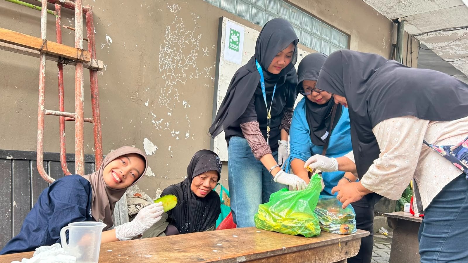 Mahasiswa KKN dan ibu-ibu PKK RW 03 Sawahan memilah serta memotong limbah buah sebagai bahan eco-enzyme