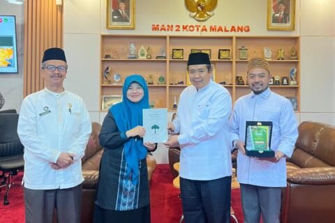 Kepala MAN 2 Kota Malang, Dr. Samsudin, M.Pd. (paling kiri), mendampingi momen penyerahan cendera mata berupa buku dan plakat kenang-kenangan bersama perwakilan delegasi Pondok Pesantren Al-Ikhlas Ujung Bone pada sela-sela kegiatan studi inspirasi.