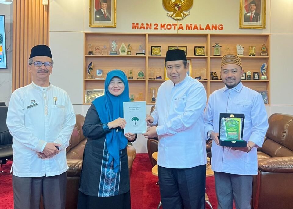 Kepala MAN 2 Kota Malang, Dr. Samsudin, M.Pd. (paling kiri), mendampingi momen penyerahan cendera mata berupa buku dan plakat kenang-kenangan bersama perwakilan delegasi Pondok Pesantren Al-Ikhlas Ujung Bone pada sela-sela kegiatan studi inspirasi.
