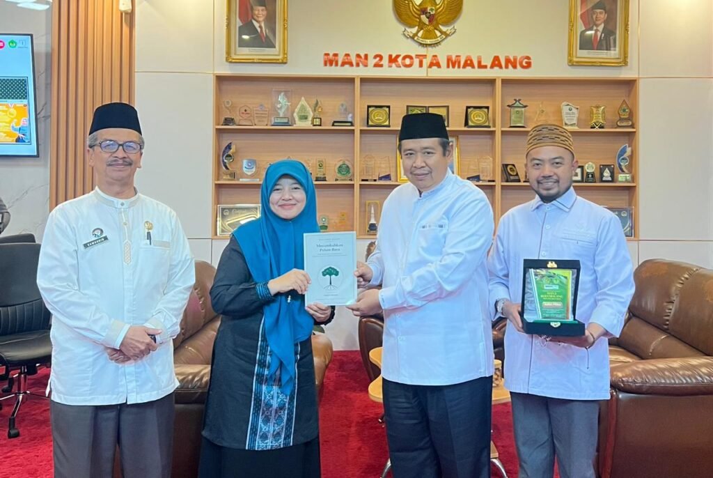 Kepala MAN 2 Kota Malang, Dr. Samsudin, M.Pd. (paling kiri), mendampingi momen penyerahan cendera mata berupa buku dan plakat kenang-kenangan bersama perwakilan delegasi Pondok Pesantren Al-Ikhlas Ujung Bone pada sela-sela kegiatan studi inspirasi.