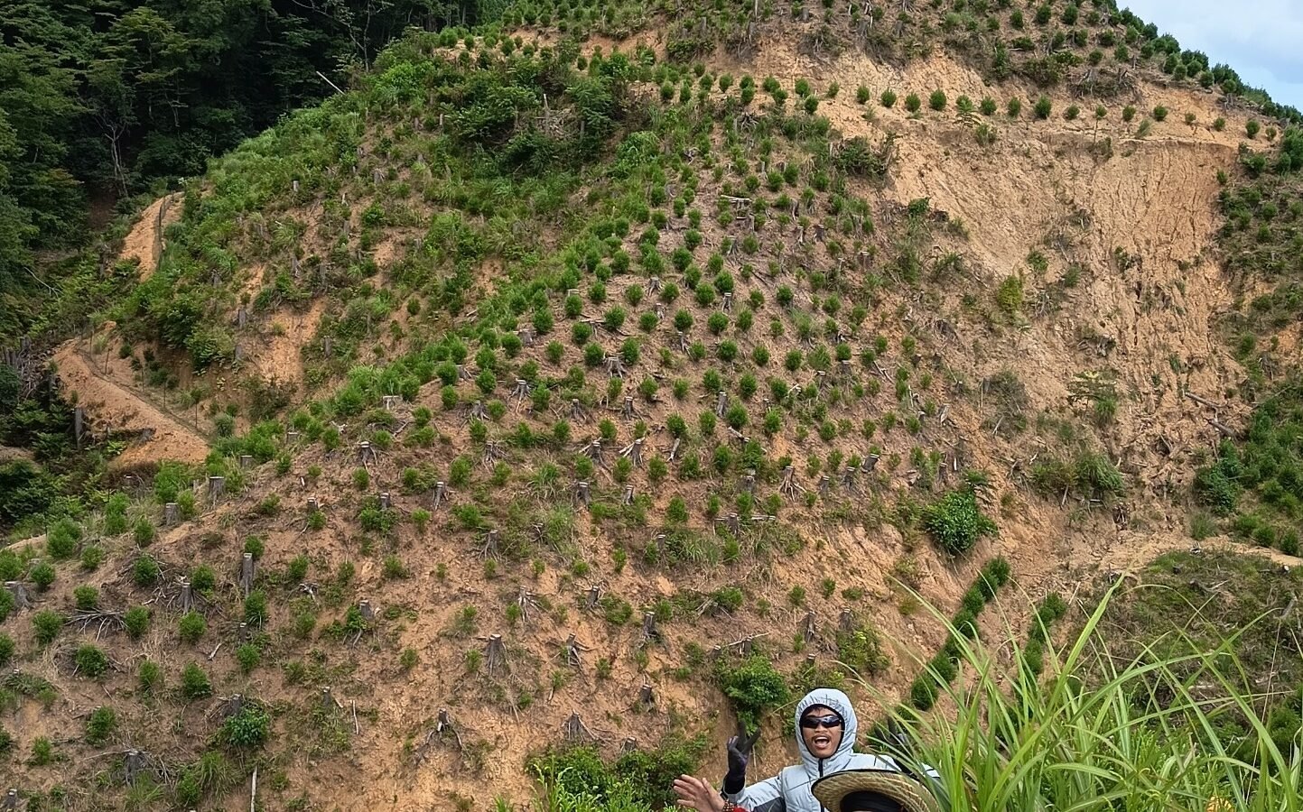 Adib Minanur Rohman (bawah) bersama tim saat rehat sejenak di area perbukitan hutan Fukuoka, Jepang, usai melakukan pemeliharaan dan penanaman bibit pohon yang menerapkan standar K3 ekstra ketat.