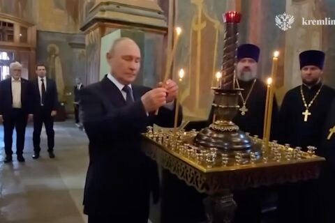 Vladimir Putin menyalakan lilin di dalam Katedral Malaikat Agung Kremlin