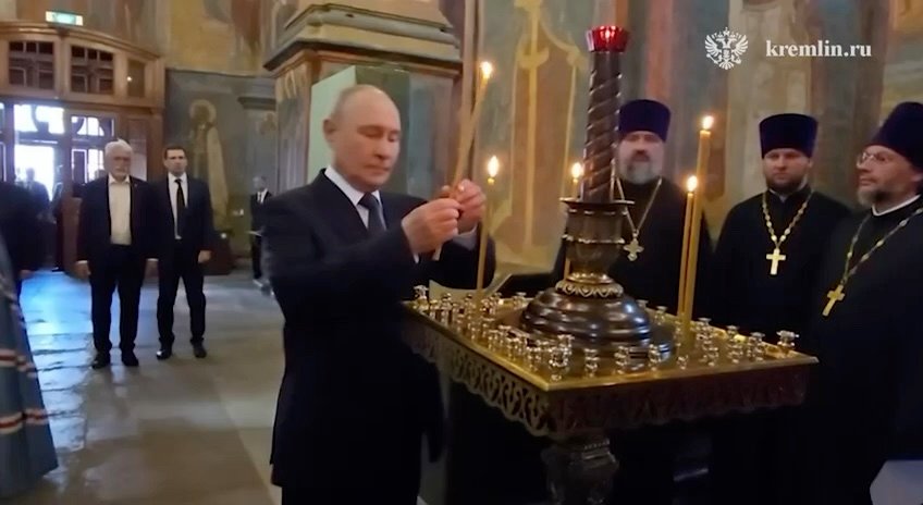 Vladimir Putin menyalakan lilin di dalam Katedral Malaikat Agung Kremlin