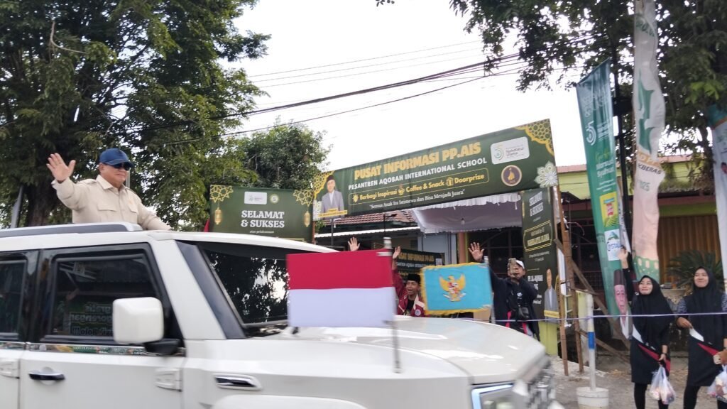 Presiden Prabowo menyapa warga dari kap mobil garuda