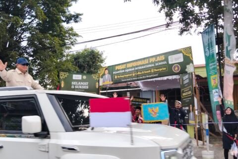 Presiden Prabowo menyapa warga dari kap mobil garuda