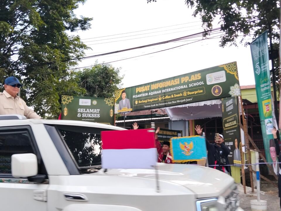 Presiden Prabowo menyapa warga dari kap mobil garuda