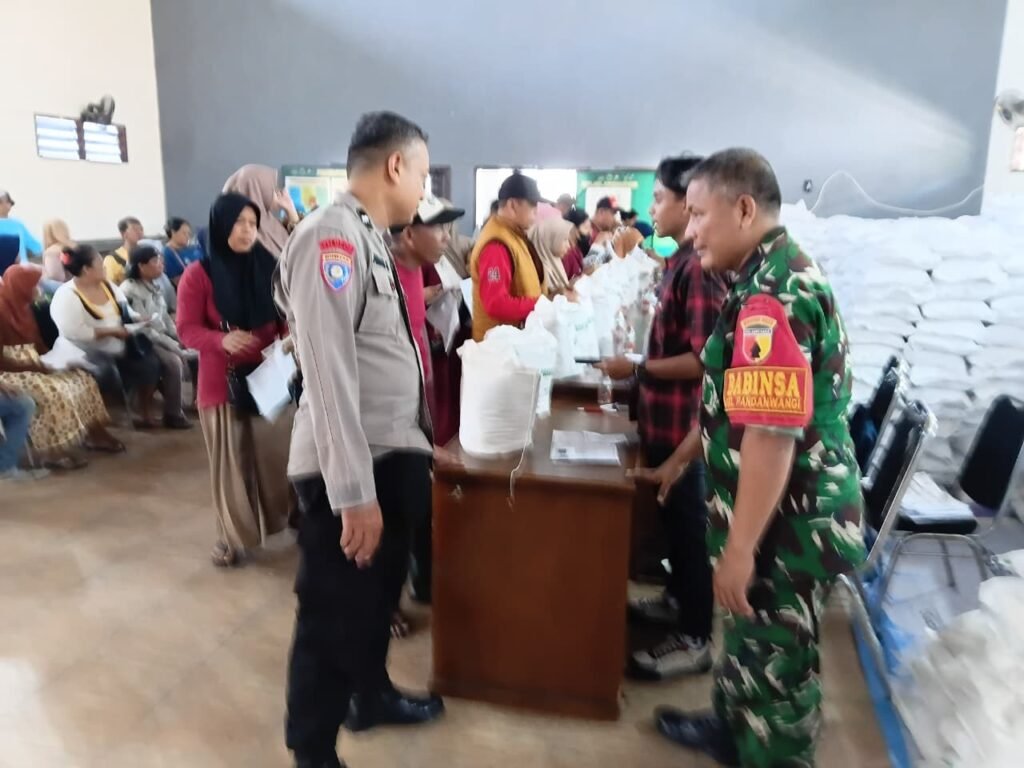 Babinsa Pandanwangi, Serma Sunyitno, bersama aparat kepolisian tengah bersinergi mengawal langsung proses verifikasi dan pembagian bantuan beras dari Bulog kepada warga penerima manfaat