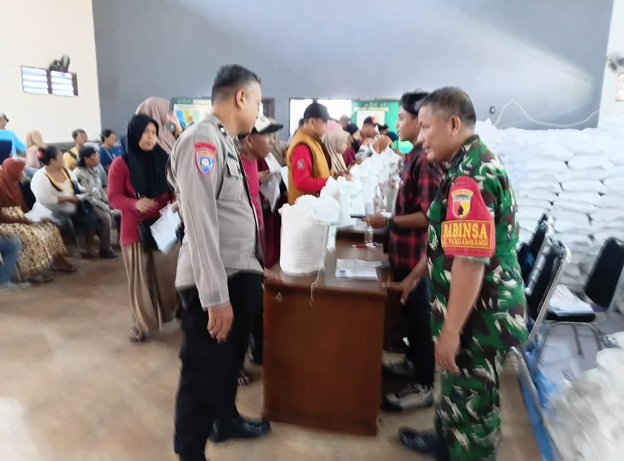 Babinsa Pandanwangi, Serma Sunyitno, bersama aparat kepolisian tengah bersinergi mengawal langsung proses verifikasi dan pembagian bantuan beras dari Bulog kepada warga penerima manfaat