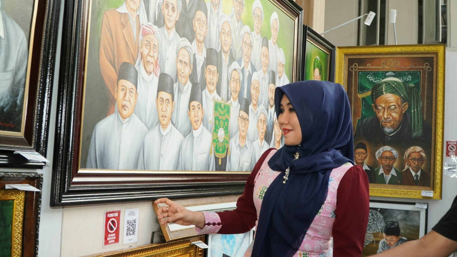 Anggota MPR/DPD RI Jatim, Lia Istifhama, tampak kagum saat mengamati lukisan wajah para muasis (pendiri) NU karya seniman lokal di Ponpes Bahrul Ulum Tambakberas, Jombang.