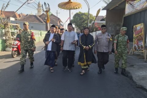 Babinsa Koramil 0833-02/Kedungkandang, Peltu Sugiantoro dan Kopka Aris, bersama aparat kepolisian dan tokoh masyarakat tampak guyub berjalan beriringan mengawal kelancaran prosesi tradisi Bersih Desa.