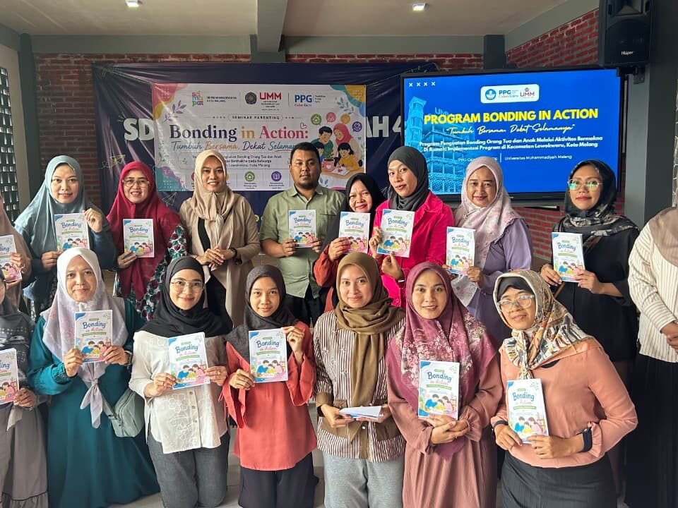 Para peserta dan mahasiswa PPG UMM mengabadikan momen kebersamaan sembari memegang buku panduan program Bonding in Action di SD Muhammadiyah 4 Kota Malang.