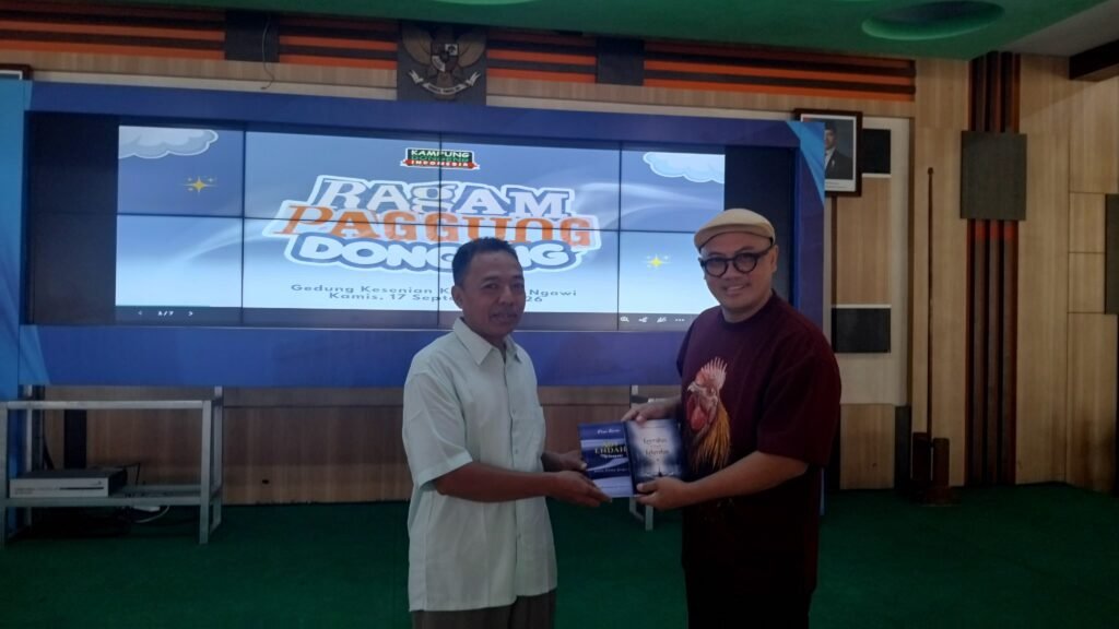 Agustiawan menyerahkan buku karyanya kepada Founder Kampung Dongeng Indonesia, Kak Awam di Gedung Kesenian Kabupaten Ngawi dalam Ragam Panggung Dongeng, Kamis (17/9/2026) pagi./dok.QONY