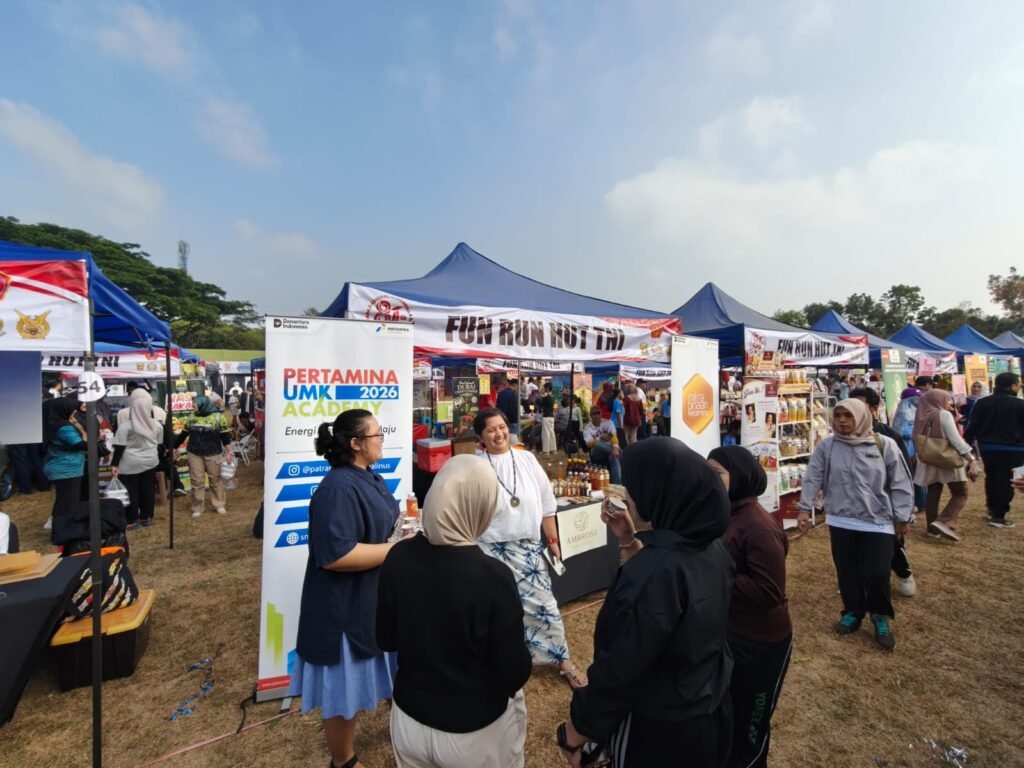 Suasana ramai pengunjung di stan pameran Pertamina UMK Academy 2026 saat gelaran Fun Run HUT TNI ke-81 di Lapangan Rampal, Malang.
