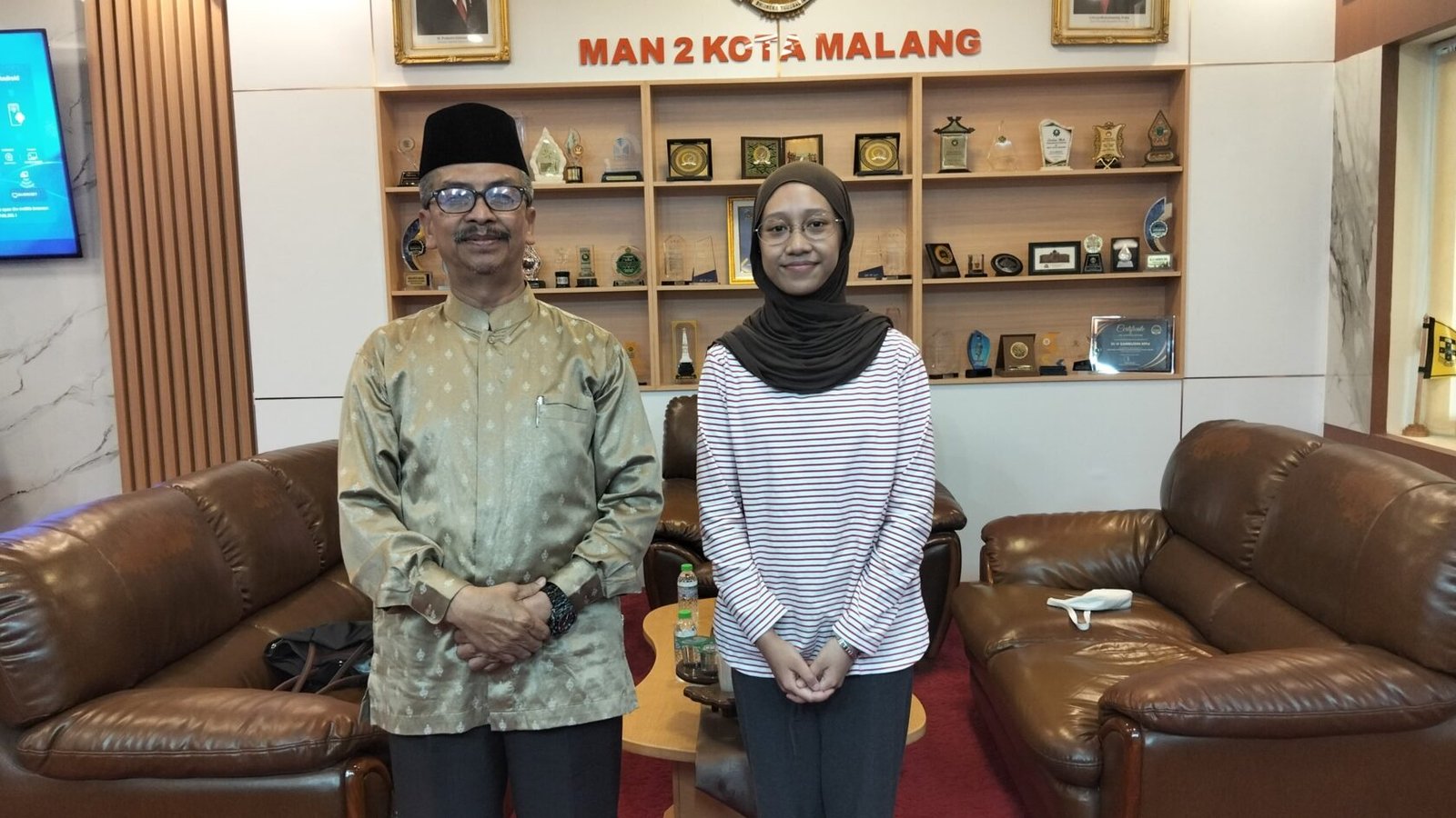 Rania, alumni angkatan 2023, berfoto bersama Kepala MAN 2 Kota Malang, Dr. H. Samsudin, M.Pd., saat berkunjung ke sekolah asalnya. Kunjungan silaturahmi ini dilakukan sebagai bentuk apresiasi setelah ia berhasil menembus program Kelas Khusus Internasional (KKI) Universitas Indonesia (UI) untuk melan
