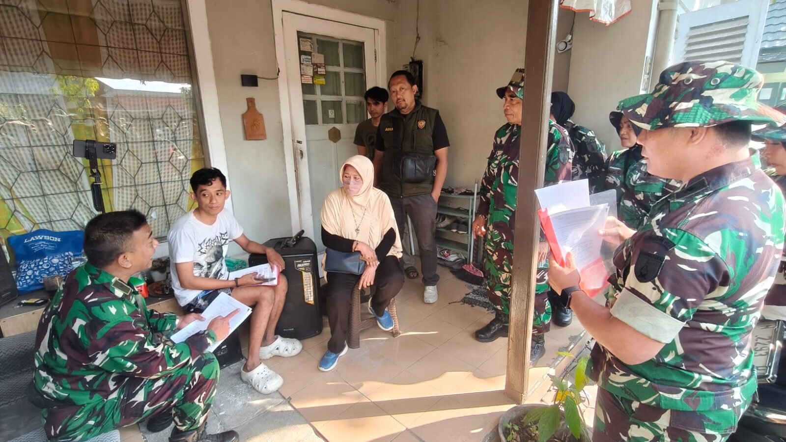 Sejumlah personel Kodim 0833/Kota Malang tengah berdialog secara persuasif sambil memeriksa kelengkapan dokumen administrasi dengan penghuni di salah satu rumah dinas.