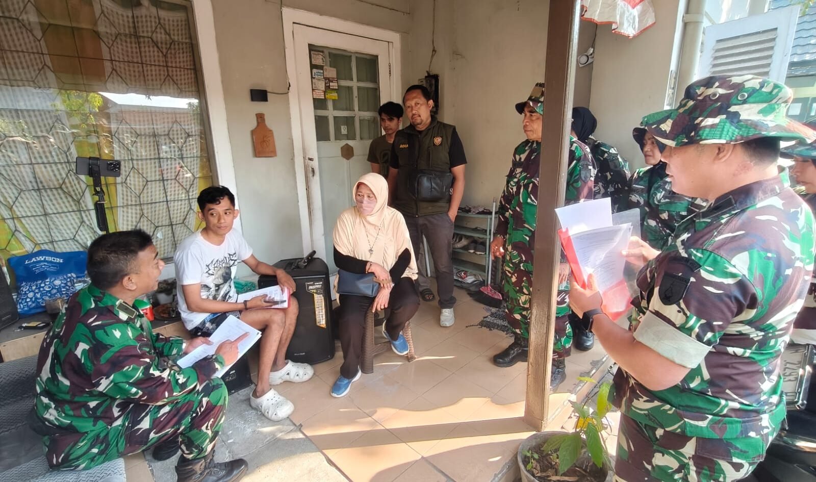 Sejumlah personel Kodim 0833/Kota Malang tengah berdialog secara persuasif sambil memeriksa kelengkapan dokumen administrasi dengan penghuni di salah satu rumah dinas.