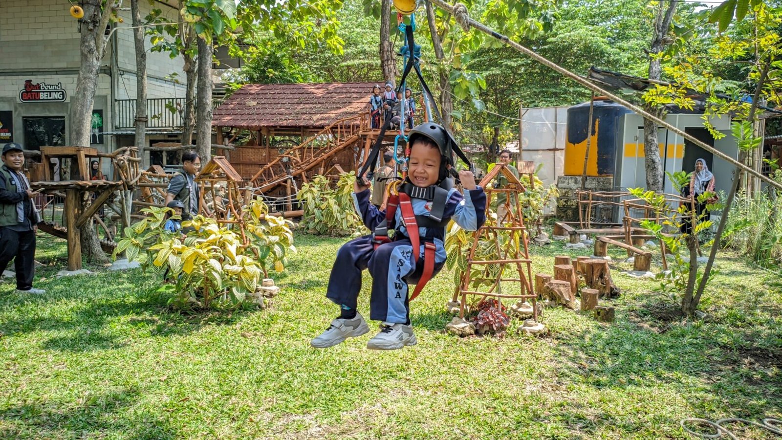 Salah seorang siswa RA Al Mustawa tampak ceria dan berani saat meluncur di wahana flying fox dengan pengamanan lengkap pada kegiatan outing class di Wisata Edukasi Mbedidhink Outbound, Graha BatuBeling, Bojonegoro.
