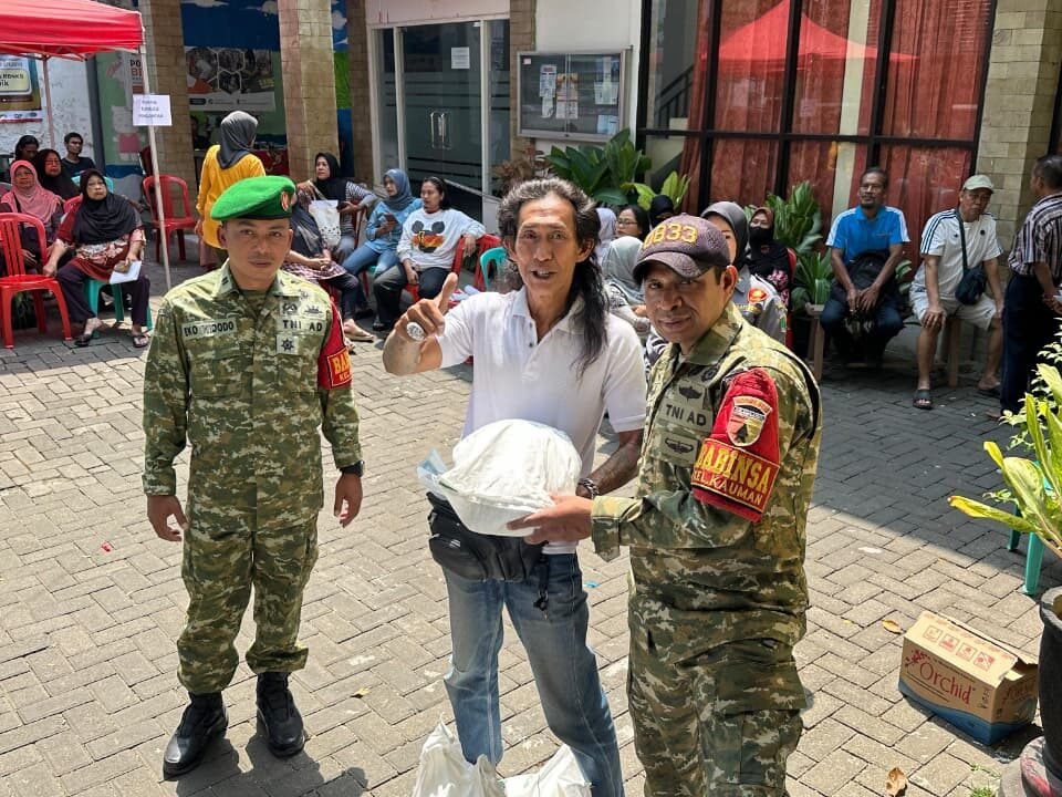 Momen antusias seorang warga yang mengacungkan jempol usai menerima paket bantuan pangan, didampingi langsung oleh Babinsa Kauman untuk memastikan kelancaran dan ketepatan sasaran distribusi.