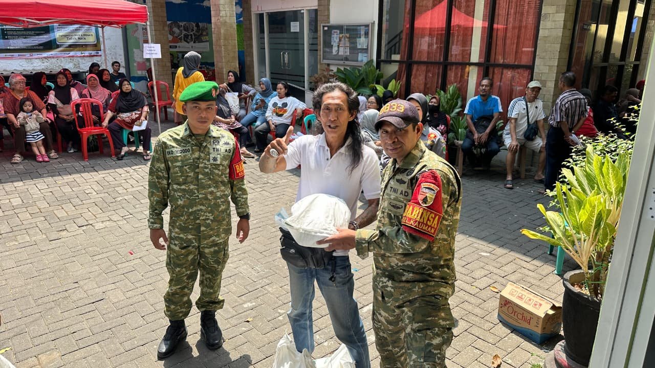 Momen antusias seorang warga yang mengacungkan jempol usai menerima paket bantuan pangan, didampingi langsung oleh Babinsa Kauman untuk memastikan kelancaran dan ketepatan sasaran distribusi.
