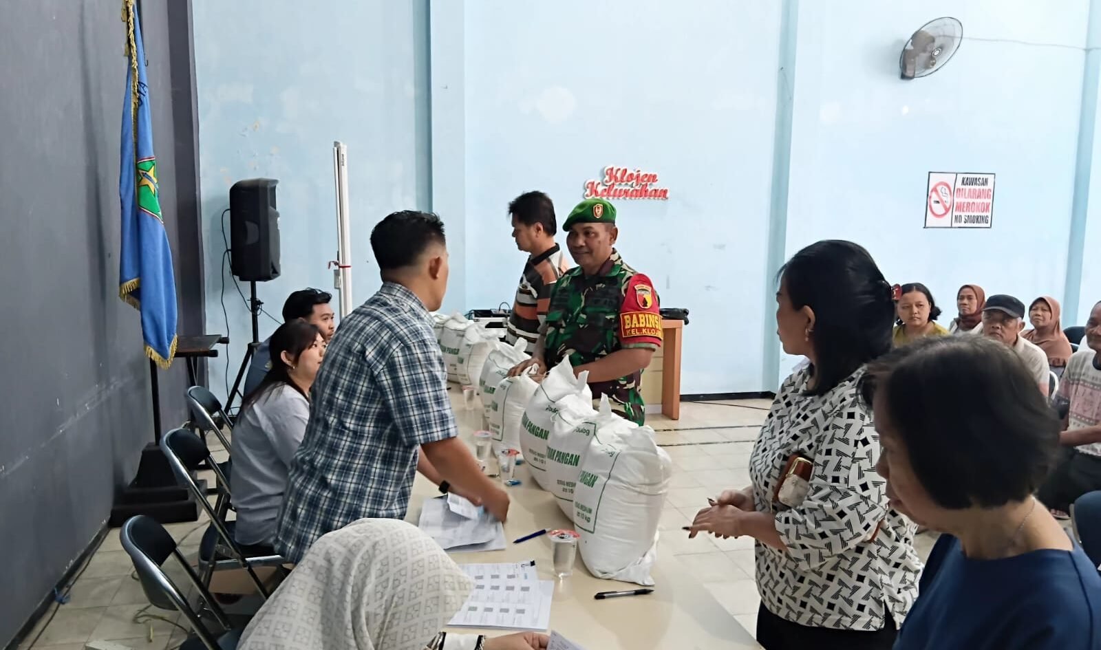 Sertu Gunawan, Babinsa Koramil 0833-01/Klojen, saat memantau dan mendampingi langsung jalannya penyaluran bantuan pangan berupa beras kepada warga di Kelurahan Rampal Celaket, Kota Malang, Senin (07/09).