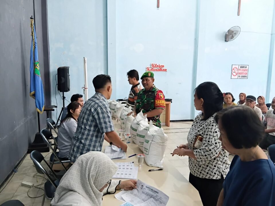 Sertu Gunawan, Babinsa Koramil 0833-01/Klojen, saat memantau dan mendampingi langsung jalannya penyaluran bantuan pangan berupa beras kepada warga di Kelurahan Rampal Celaket, Kota Malang, Senin (07/09).