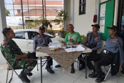 Babinsa Tulusrejo Koramil 0833-05/Lowokwaru, Serda Fajar (kiri), duduk santai sembari berdialog menyerap aspirasi dan berkoordinasi bersama anggota Linmas serta warga di Kelurahan Tulusrejo, Kota Malang, Minggu (20/9/2026).