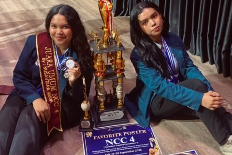 Dua mahasiswa delegasi FBiPK Universitas Brawijaya tersenyum bangga memamerkan piala Juara Umum, selempang kejuaraan, medali, serta sertifikat penghargaan Nusantara Creative Competition (NCC) 4 di Universitas Udayana, Bali.