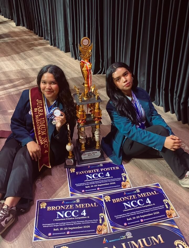 Dua mahasiswa delegasi FBiPK Universitas Brawijaya tersenyum bangga memamerkan piala Juara Umum, selempang kejuaraan, medali, serta sertifikat penghargaan Nusantara Creative Competition (NCC) 4 di Universitas Udayana, Bali.