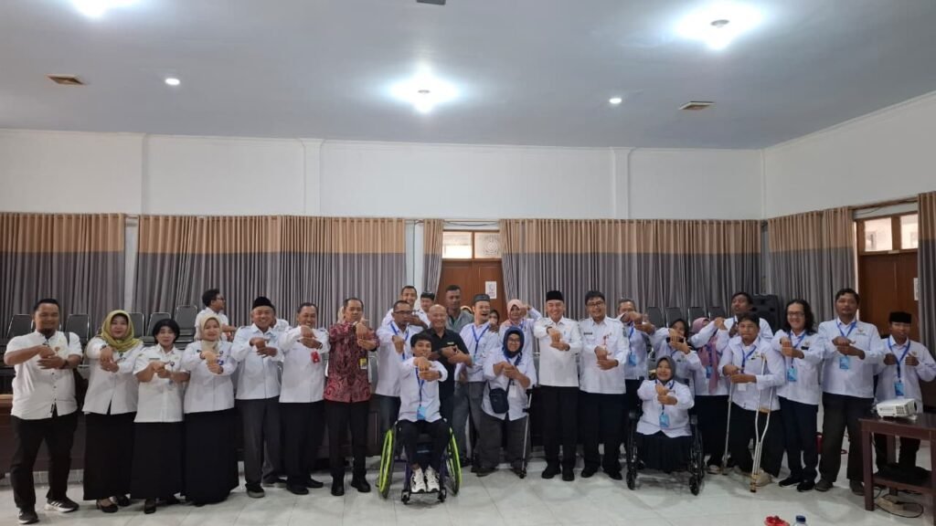 Para peserta penyandang disabilitas bersama jajaran panitia dan perwakilan Disnakertrans berfoto bersama usai pembukaan program pelatihan dan penempatan kerja sektor formal di Jawa Timur.