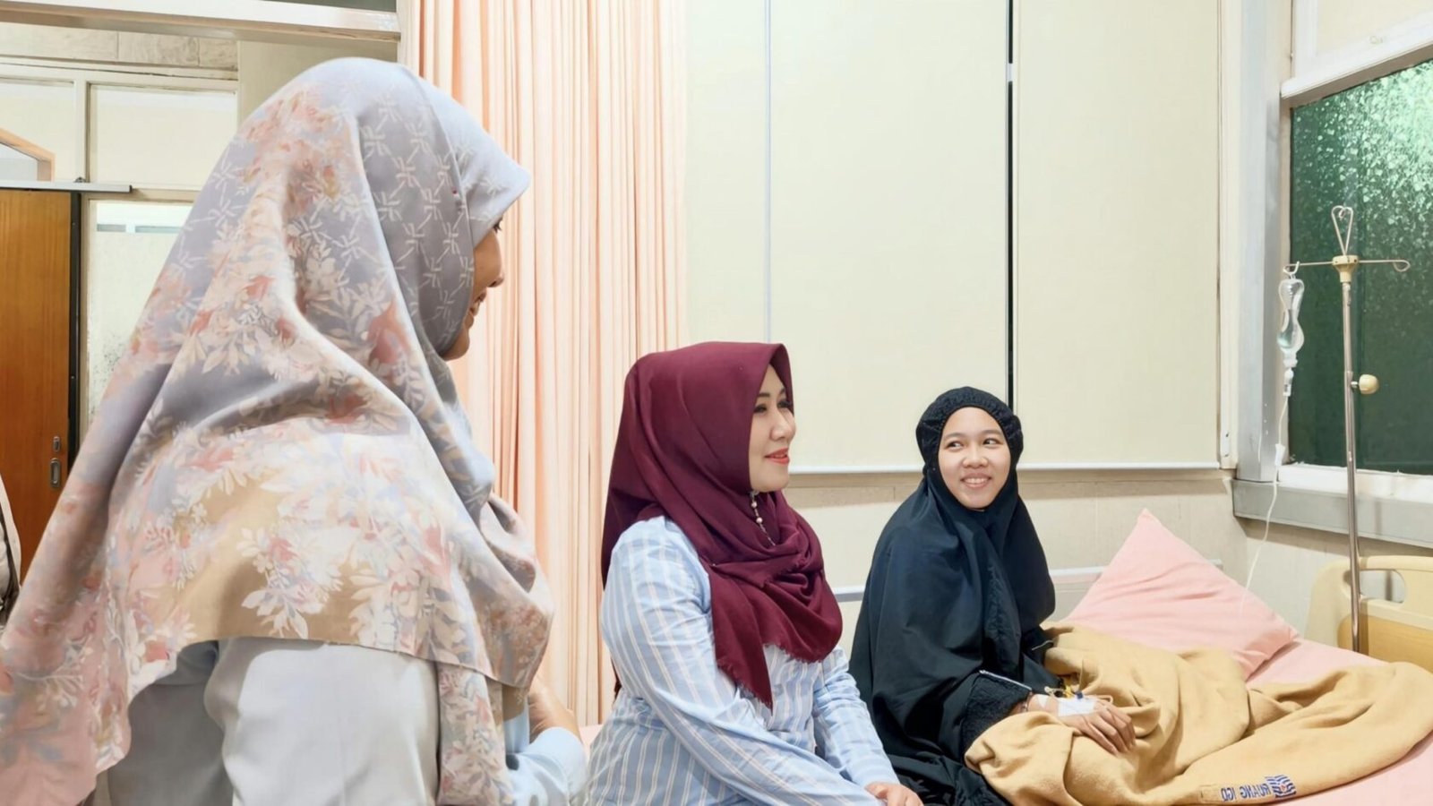 Anggota DPD RI, Lia Istifhama (kiri), tampak berbincang hangat saat menjenguk korban keracunan program Makan Bergizi Gratis yang tengah menjalani perawatan intensif di rumah sakit, Rabu malam (2/9/2026).