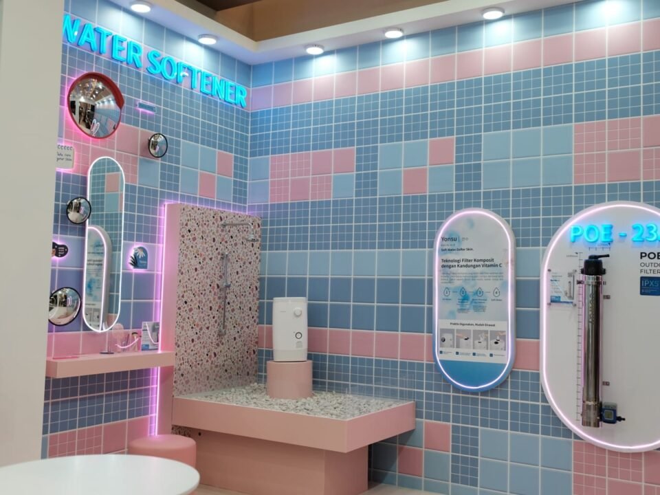Tampilan stan Coway bernuansa pastel di ajang IndoBuildTech (IBT) Surabaya 2026 yang memamerkan produk terbaru water softener Yonsu serta sistem filter air luar ruangan POE-23A.