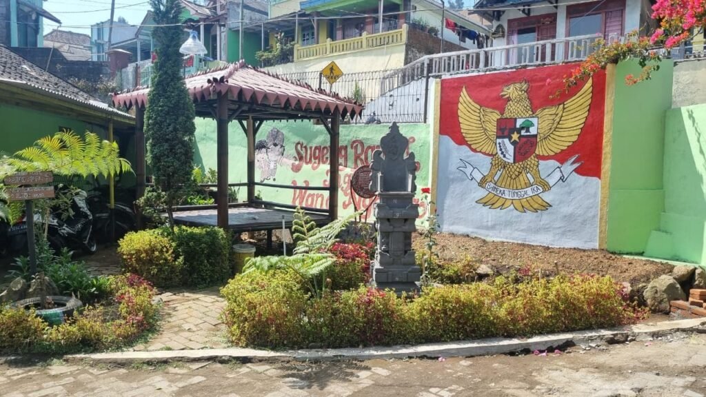 Sudut ruang terbuka Kampung Pancasila Desa Ngadirejo yang asri, memadukan mural lambang negara dengan ornamen budaya toleransi setempat.