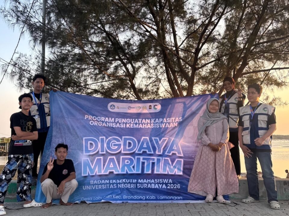 Tim PPK Ormawa BEM UNESA 2026 berfoto bersama perwakilan pemuda Desa Labuhan berlatar senja Pantai Kutang seusai menggelar pelatihan Content Planner & Footage Editing, Minggu (16/8/2026).