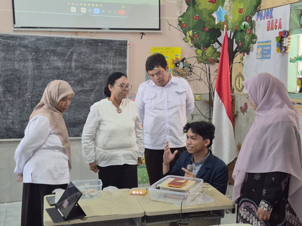 Tim pengembang mendemonstrasikan teknis navigasi dan cara kerja perangkat Lantai Pintar Geometri di hadapan para guru dan kepala sekolah. (Foto: Dok. Tim PkM UB)