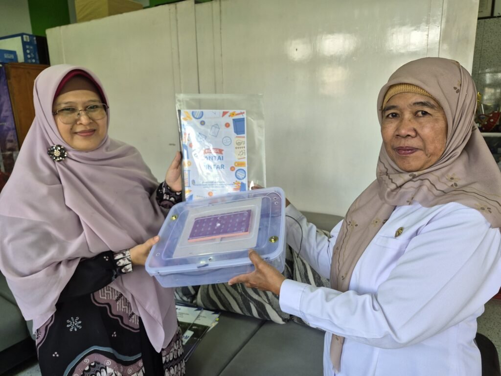 Ketua Tim PkM UB Dr. Sa’adatul Fitri, M.Sc. menyerahkan modul dan unit peraga Lantai Pintar Geometri kepada Kepala SDN Giripurno 01 Batu Eny Isnaini, S.Pd., M.Pd.