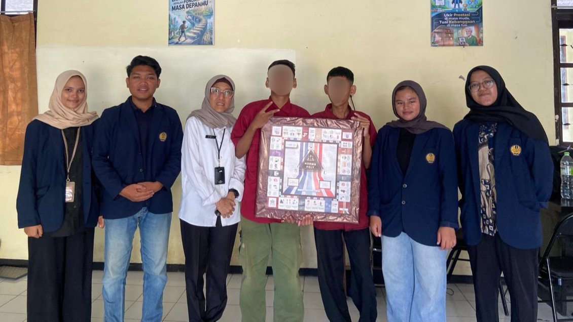 Sejumlah mahasiswa PPKn berfoto bersama instruktur dan Anak Penerima Manfaat (PM) di UPT PRSMP Surabaya sembari menunjukkan papan permainan monopoli hasil modifikasi, Jumat (11/09).
