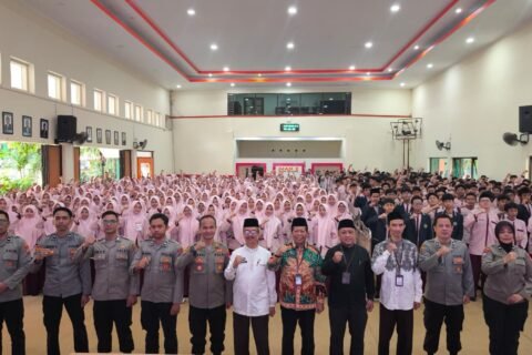 Jajaran personel Satbinmas Polresta Malang Kota bersama pejabat Kemenag dan pimpinan madrasah berfoto bersama ratusan siswa kelas X usai agenda Sosialisasi dan Simulasi Program Paham AI di Aula MAN 2 Kota Malang.