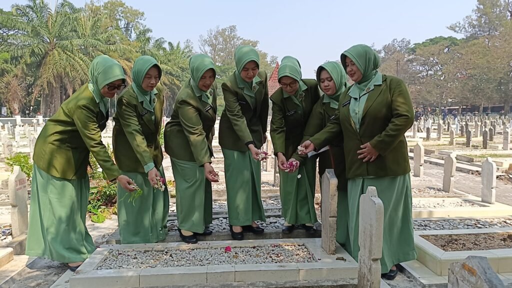 Anggota Persit KCK Cabang XL Dim 0833 khidmat melakukan prosesi tabur bunga di pusara makam pahlawan saat peringatan HUT ke-81 TNI di TMP Untung Suropati, Kota Malang, Senin (28/9/2026).