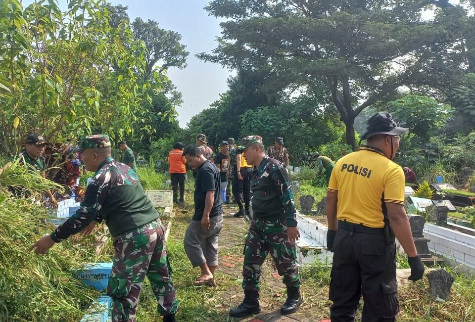 Personel Koramil 0833-03/Blimbing bersama aparat kepolisian dan warga bergotong royong membersihkan rumput liar di TPU Kelurahan Pandanwangi, Kota Malang, dalam rangka menyambut HUT ke-81 TNI, Selasa (22/09).
