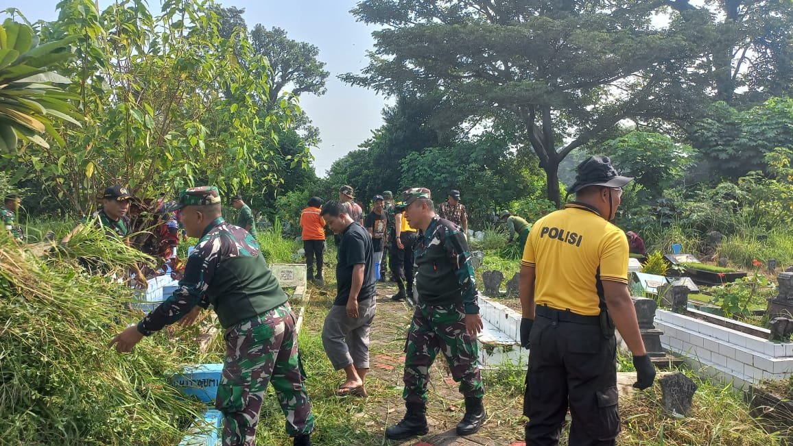 Personel Koramil 0833-03/Blimbing bersama aparat kepolisian dan warga bergotong royong membersihkan rumput liar di TPU Kelurahan Pandanwangi, Kota Malang, dalam rangka menyambut HUT ke-81 TNI, Selasa (22/09).