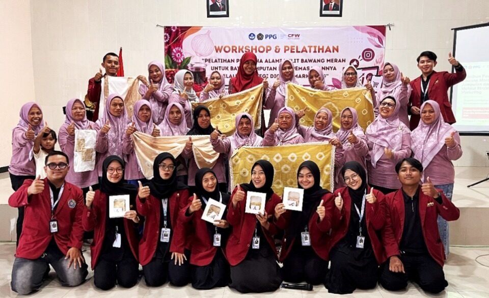 Sinergi Kreatif: Mahasiswa PPG PGSD Universitas Muhammadiyah Malang (UMM) berfoto bersama anggota KWT Putri Pandan Wangi sembari memamerkan hasil kain batik jumputan menggunakan pewarna alami 'Allium Dye' dari limbah kulit bawang merah di Balai Dusun Klerek, Torongrejo, Kota Batu.