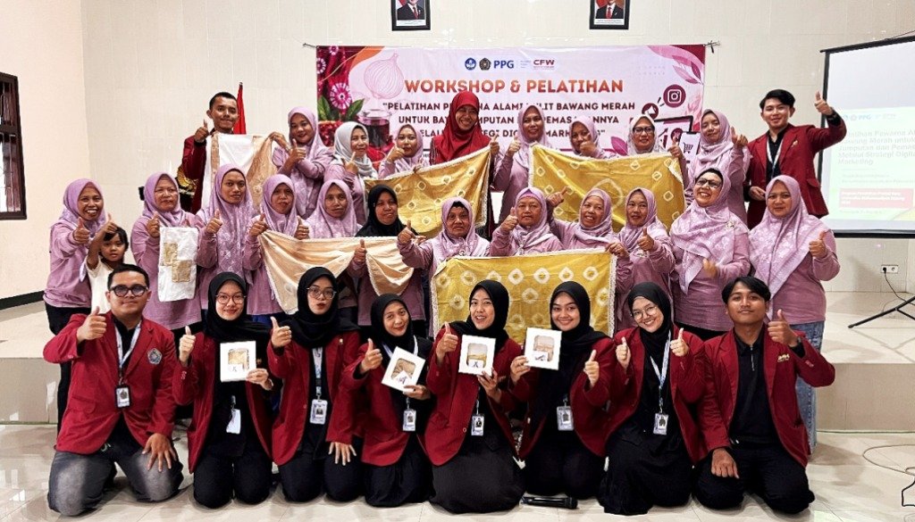 Sinergi Kreatif: Mahasiswa PPG PGSD Universitas Muhammadiyah Malang (UMM) berfoto bersama anggota KWT Putri Pandan Wangi sembari memamerkan hasil kain batik jumputan menggunakan pewarna alami 'Allium Dye' dari limbah kulit bawang merah di Balai Dusun Klerek, Torongrejo, Kota Batu.